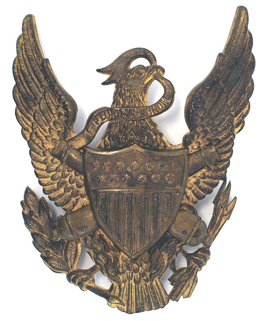 US M1881 helmet plate Artillery Regiment: K-104 US M1881 helmet plate for the dress helmet for the enlisted men of an Artillery Regiment. Age toned gilt American eagle, shield, crossed cannons, arrows and olive branch. Three Wire loops on rev