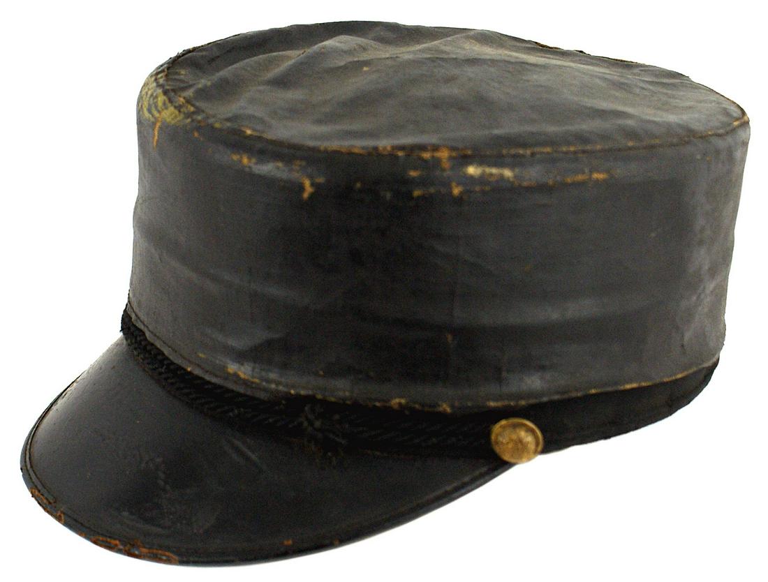 US Spanish American War M1895 cap cheese wheel: K-188 US Spanish-American War M1895 "cheese wheel" type cap. Large leather visor and a black cord chinstrap and brass eagle side buttons. With original black rain cover. Lining has the name of the ret