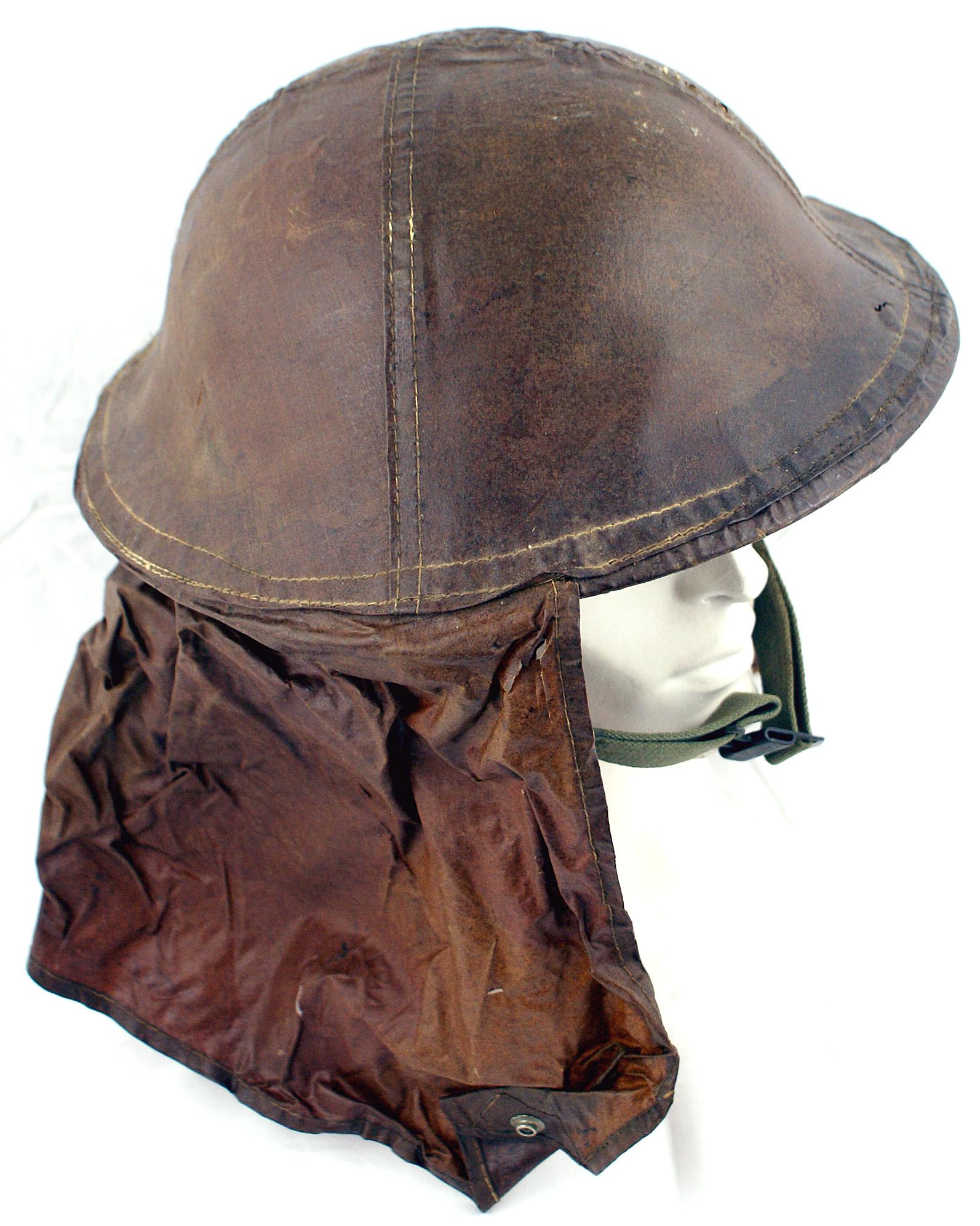 WWII era helmet British style: E-017 WWII Era helmet. British style. With an unusual, fitted plastic rain cover with a neck shield which reaches around and has a snap button below the chin. Marked with maker "IRISTO - GALI.ONY. - 1