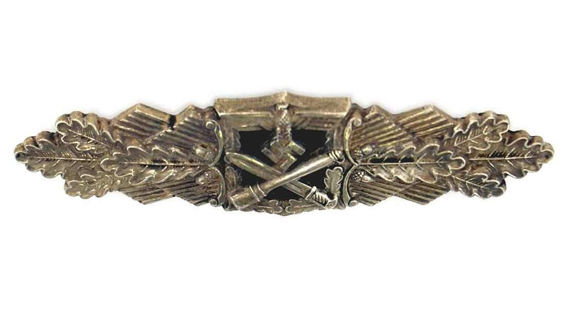 German WWII Army Silver Close Combat Clasp: B-050 German WWII Army Silver Close Combat Clasp. Measures 3 7/8" by 1 1/16" tall. The front has a German eagle clutching a swastika in his talons at the top with a crossed bayonet and stick grenade b