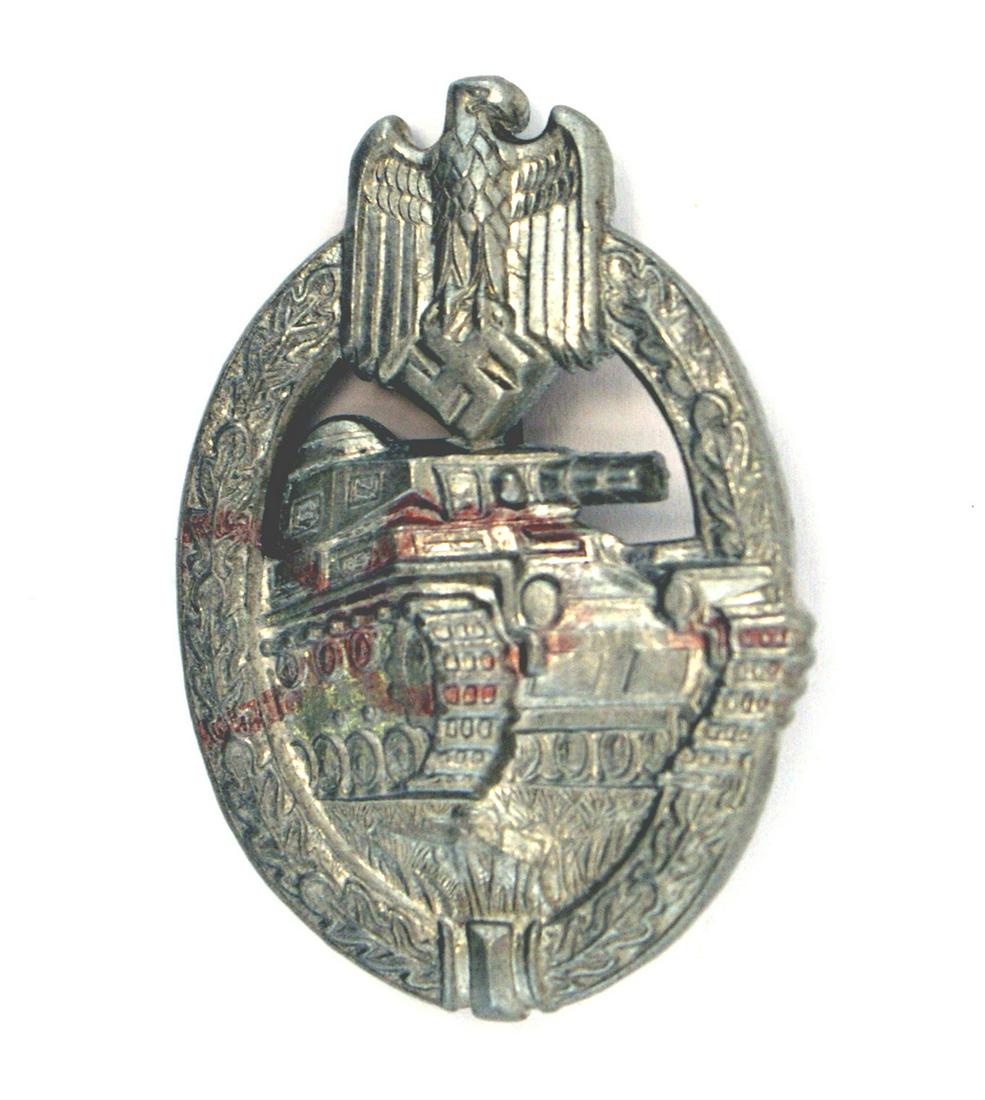 German WWII Army Silver Tank Assault Badge: B-055 German WWII Army Silver Tank Assault Badge. Measures 1 5/8" wide by 2 3/8" tall. The front shows a tank in the center with an Army eagle clutching a swastika in his talons at the top. Both are s