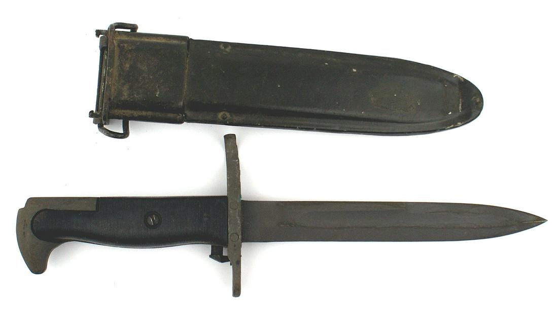 Variation US M1942 knife bayonet: D-059 Variation US M1942 knife-bayonet. Parkerized eagle head pommel and unmarked crossguard. Lined black plastic grips. Parkerized 7/8" wide, 6 1/2" blade. Blackened M-7 type metal throat and scabbar