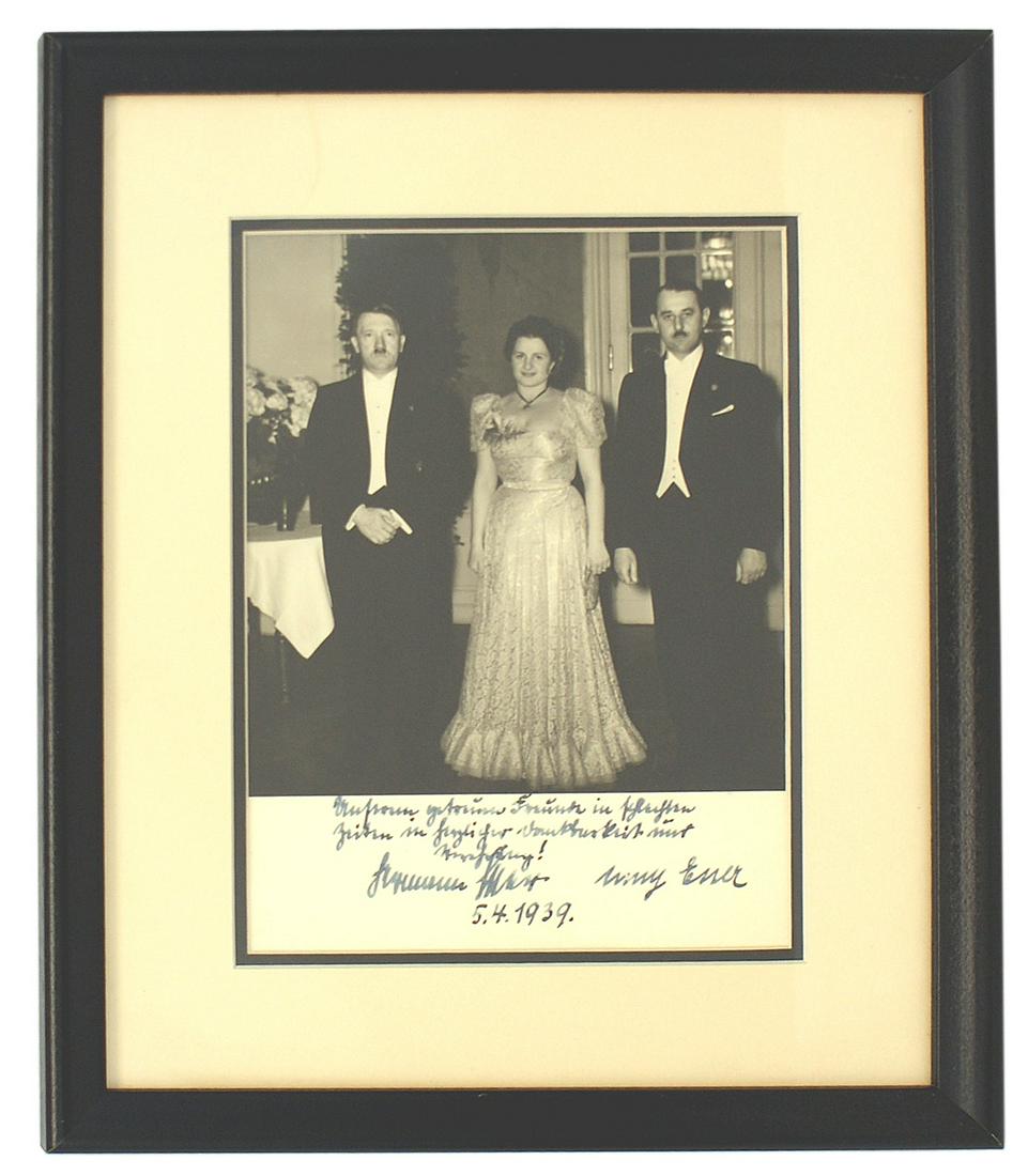 Framed photo of Adolf Hitler with Hermann Esser: A-008 Framed portrait photo of Adolf Hitler with Hermann Esser (the publisher of the Volkischer Beobachter) and his wife Emmy - all in formal attire. Matting has an ink dedication to Hitler with the s