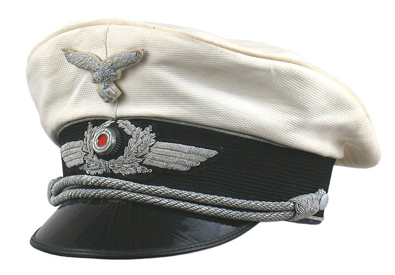 German WWII Luftwaffe white peaked cap: E-109 Luftwaffe officer's white topped. "Waffle" pattern cover on black band with (oxidized) silver bullion piping. Removable eagle/swastika on a white background has oxidized to a white powdery subst