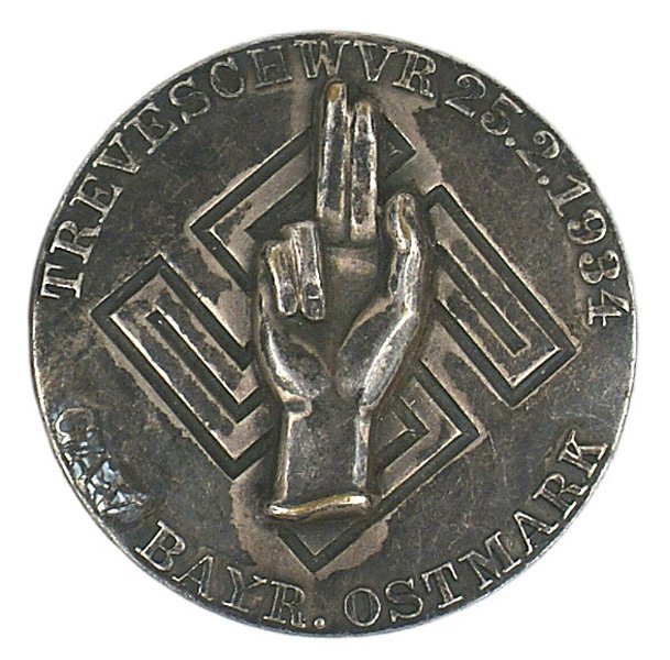 German WWII GAU 1934 Loyalty Day Badge: B-28 Silvered "GAU. BAYR. OSTMARK…25.2.1934" Loyalty Day Badge. Applied hand (showing the loyalty sign) on an engraved swastika. Nice aged plum patina. Solid type - maker marked "R.WACHTER & LANGE M