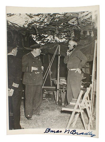 Photo Winston Churchill signed Omar N. Bradley: S-7 Wartime field photo of a uniformed, cigar smoking Winston Churchill visiting U.S. General Bradley. Ink signed "Omar N. Bradley". 4 5/8" x 4". II