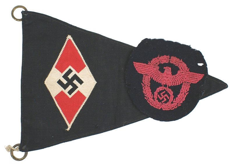 German WWII Hitler Youth bicycle pennant: H-115 H.J. (Hitler Youth) bicycle pennant. 4" x 2 1/8" embroidered HJ swastika/red and white diamond on a black triangular field. Brass rings in corners. Overall 5 1/8" x 8 5/8". Also with an embroide
