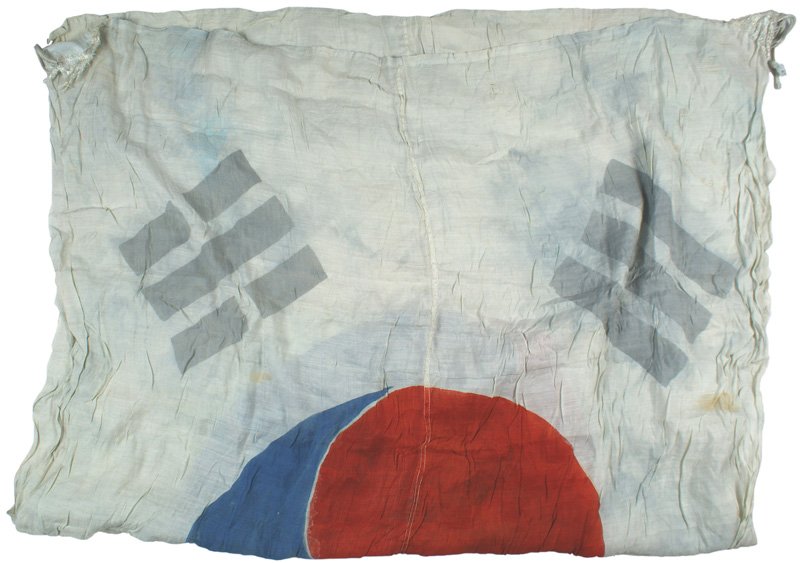 Republic of South Korea silk flag: H-218 Republic of South Korea silk flag. Blue/red stenciled "Yin-Yang" on a white field with printed black "bars" in corners. White cord ties. One of the corner tabs is frayed - but flag is not. 50" x