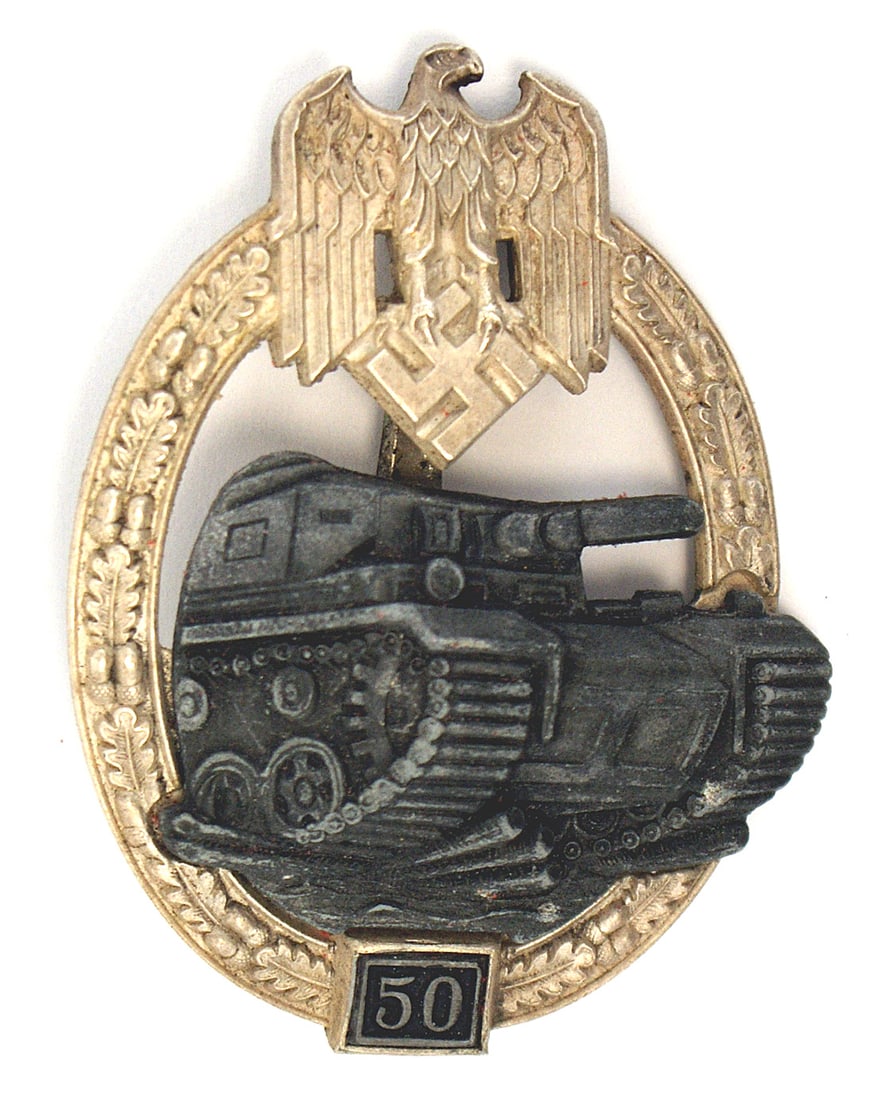 German WWII Panzer Badge 50 Engagements: B-074 German WWII Panzer Badge, in silver for 50 Engagements. Age toned silvered eagle/swastika at top of a convex open oak leaf wreath. Separately affixed darkened Panzer. Panel with "50" at bottom o