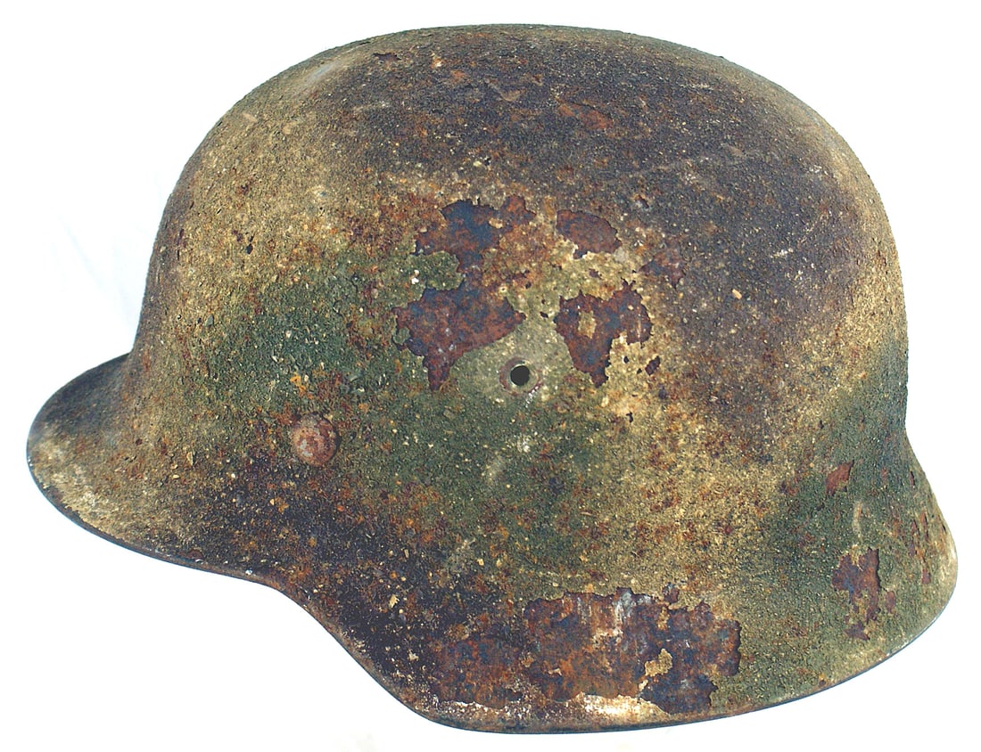 German WWII Army M1940 camo helmet: E-058 German WWII Army M1940 camouflaged helmet. "Normandy" pattern "sand finish" of large patches of light green/brown/green colors. The "caked on" finish is chipped away in two areas on the left sid