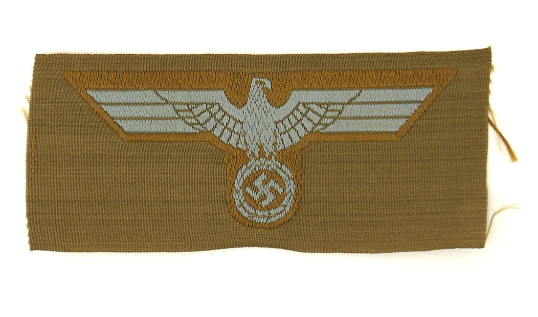 German WWII Africa Korps cap eagle: E-156 German WWII Africa Korps bevo cap eagle. Blue-gray eagle/swastika on tan backing. Uncut, in excellent condition. I