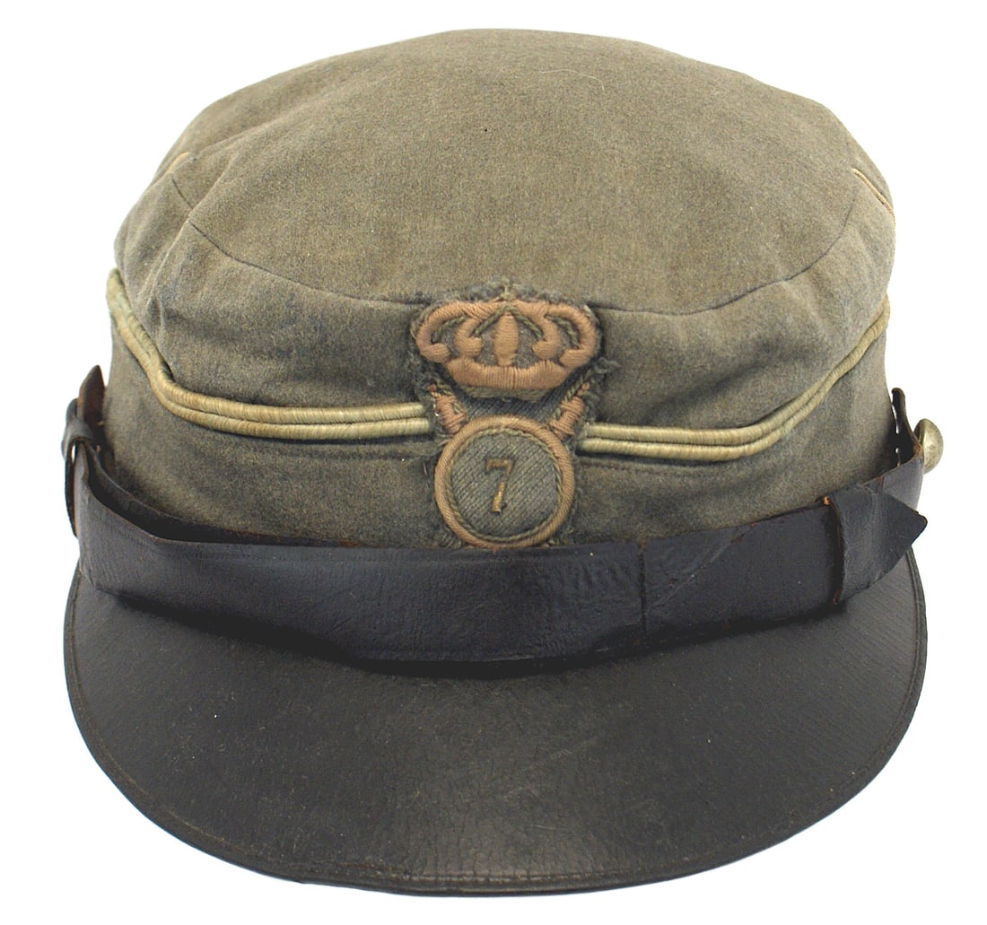Italian WWI EM Infantry kepi: E-210 Italian WWI EM Infantry kepi. Light green wool body with a green tinted piping. Large embroidered crowned crossed rifles and "7" (Regiment) insignia sewn to front. Wide black leather chinstrap a