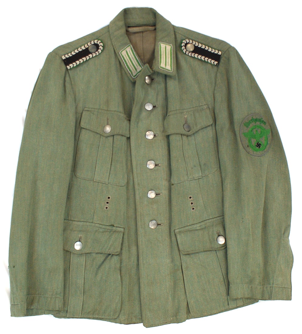 German WWII Schutzpolizei summer tunic: F-036 German Third-Reich Schutzpolizei Summer Tunic. Four-pocket green-tan cotton fabric. Open collar with six pebbled buttons. Embroidered silver bars on green backing with silver cord piping, collar
