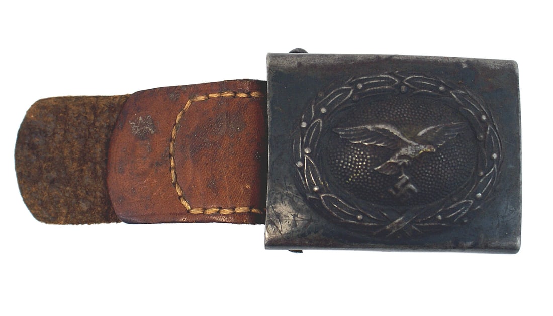 German WWII Luftwaffe EM belt buckle: H-006 German WWII Luftwaffe EM steel belt buckle. 80% blue-gray finish on the relief flying eagle within an oak leaf wreath. Leather tab marked "GERBRUDER SCHNEIDER A.G. - WIEN". II