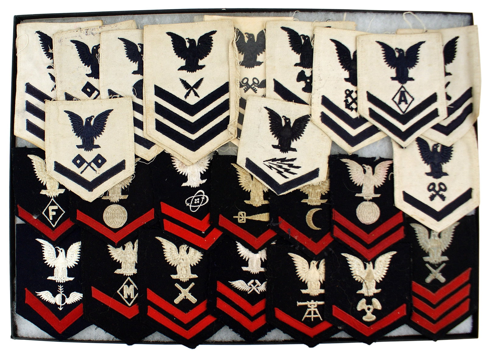 26 US Navy WWII rank specialty badges: H-134 Collection of 26 US Navy WWII embroidered rank/specialty sleeve badges. All with the Navy eagle specialty insignia and rank chevrons. Many are dated "1940", "1943" and "1944". 13 have a blue bac