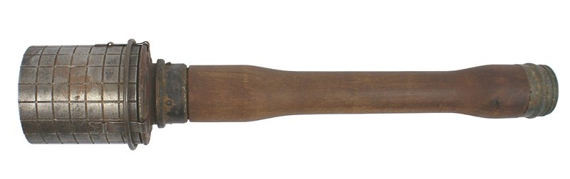 German WWII Potato masher grenade fragmentation sle: M-55 "Potato masher" with a fragmentation sleeve. Perforated small squares on circular band which is attached with three overlapping metal extensions and a circular wire loop. Handle is age stained wi
