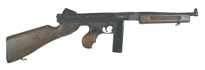 Replica U.S. WWII Thompson Submachine gun M1928 A-1: M-61 Replica of the US WWII Thompson Submachine gun M-1928 A-1. One-piece cast frame and barrel. Wood stock, grip and forearm. 20 round magazine. With sling swivels. Shows some wear. Sold as a display