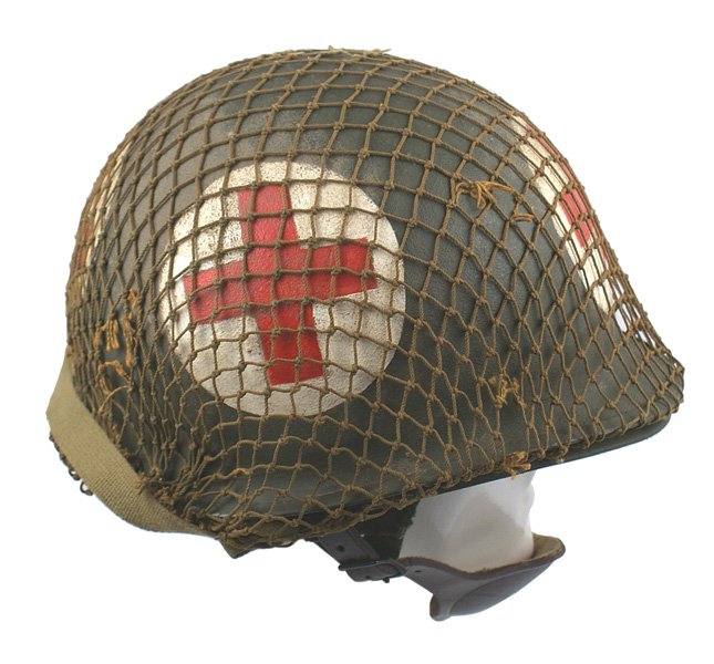 U.S. VN paratrooper medic helmet: E-73 U.S. VN paratrooper medic's helmet. O.D. finish with four large painted red Cross emblems. O.D. cord camouflage net. Snap-in fiber liner with a leather chin cup and web straps. II