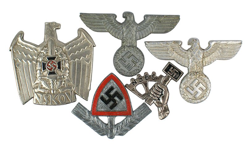 Lot fo 5 German WWII peaked cap badges: E-131 Lot fo 5 German WWII peaked cap badges: (1) DAF-winged wheel/lightning bolts/cog wheel/swastika. (2) Two Police-eagle/swastika wreath. Silvered and aluminum types. (3) Two early type NSDAP/HJ ty