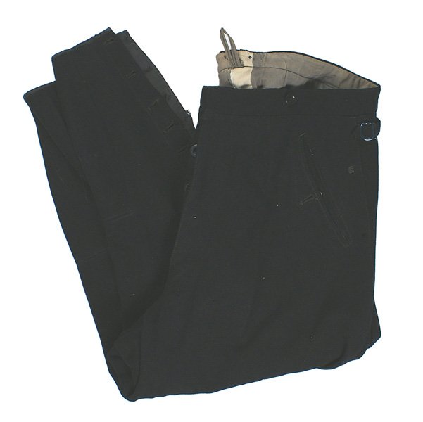 German WWII SS black wool breeches: F-26 German WWII SS black wool breeches. Two slant button down pockets. Button up bottoms. "RZM HOSE SS" oilcloth label. Size 38. 1" period professional repair on inside of left ankle. II