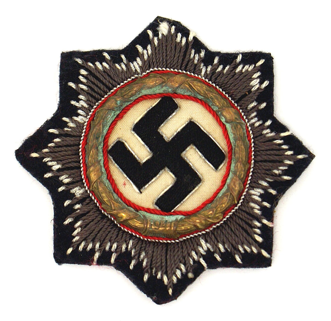 German WWII Panzer Waffen SS embroidered Cross: B-025 German WWII Panzer/W-SS embroidered German Cross in Gold. Relief silver bordered black swastika on a white field. All within a gilt metal oak leaf wreath with the date "1941" (some verdigris). T