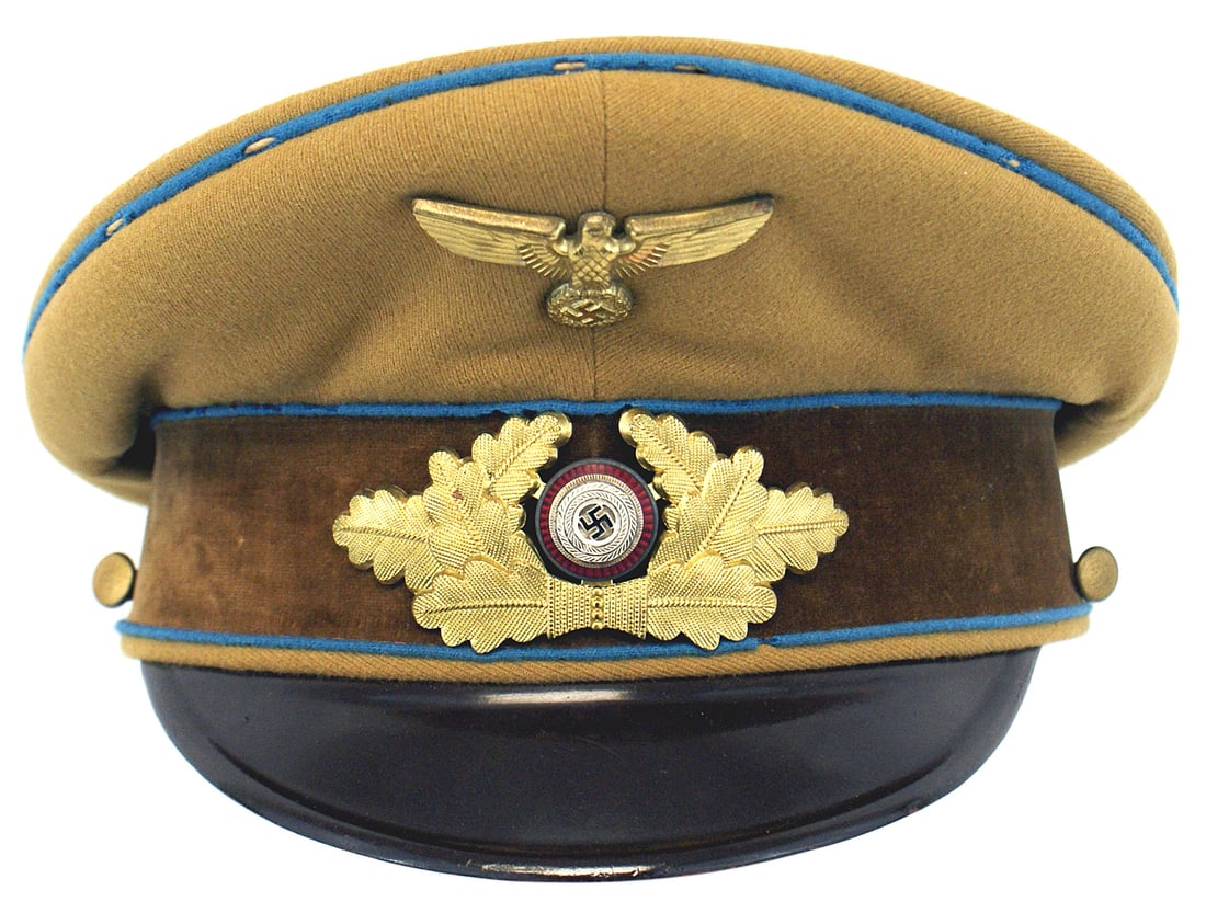 German WWII NSDAP Orts Level peaked cap: E-043 Third-Reich N.S.D.A.P. Orts Level Political Leaders peaked cap. Gold-brown body with a brown velour band and blue piping. Mothing on the piping along the perimeter of the cap. Age toned gilt eag