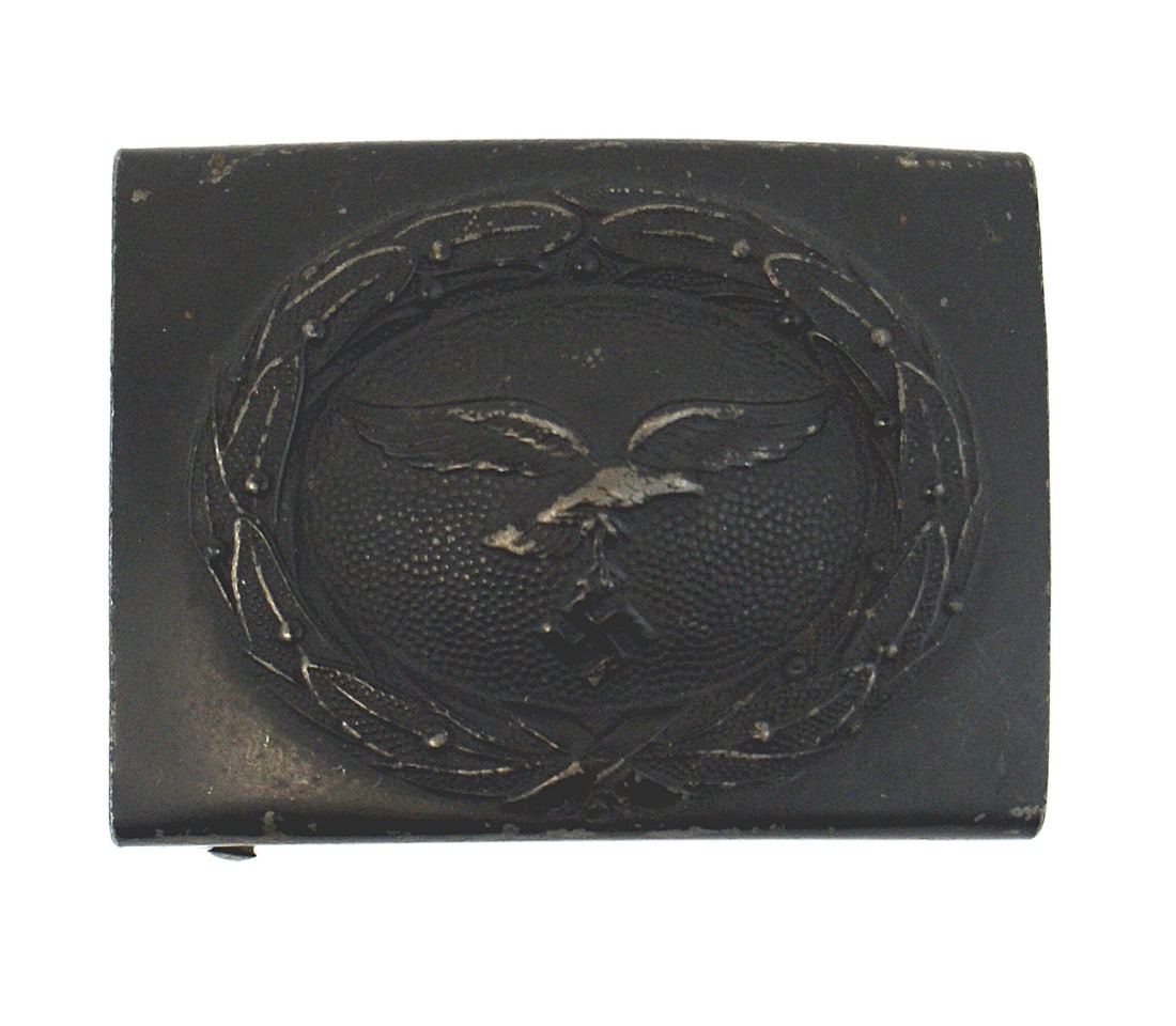 German WWII Luftwaffe EM belt buckle: H-010 German WWII Luftwaffe E.M. steel belt buckle. Relief flying eagle/swastika within an oak leaf wreath. 95% blue-gray finish. II+