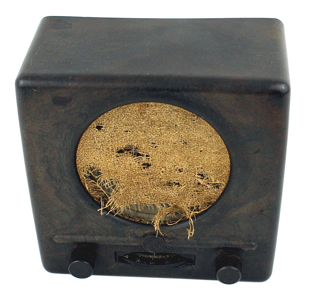 German WWII Volks Peoples Radio: H-082 German WWII "People's Radio". The method used in the Third-Reich to propagandize the German population. 4 5/8" x 9 1/4" x 9 1/4" bakelite body with a 5" diameter torn cloth screen. Subdued eagle
