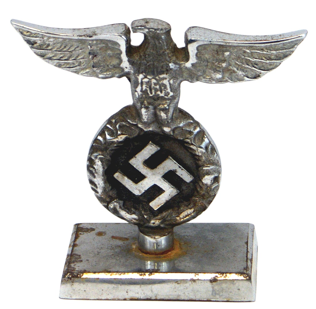 German WWII variant desk eagle: G-011 German Third Reich variant desk eagle. One-piece nickel-plated iron eagle/oak leaf wreath/relief swastika. 3 3/4" x 4 5/8" eagle is mounted on a round 1/4" round base and attached to a 3 1/8 x 2