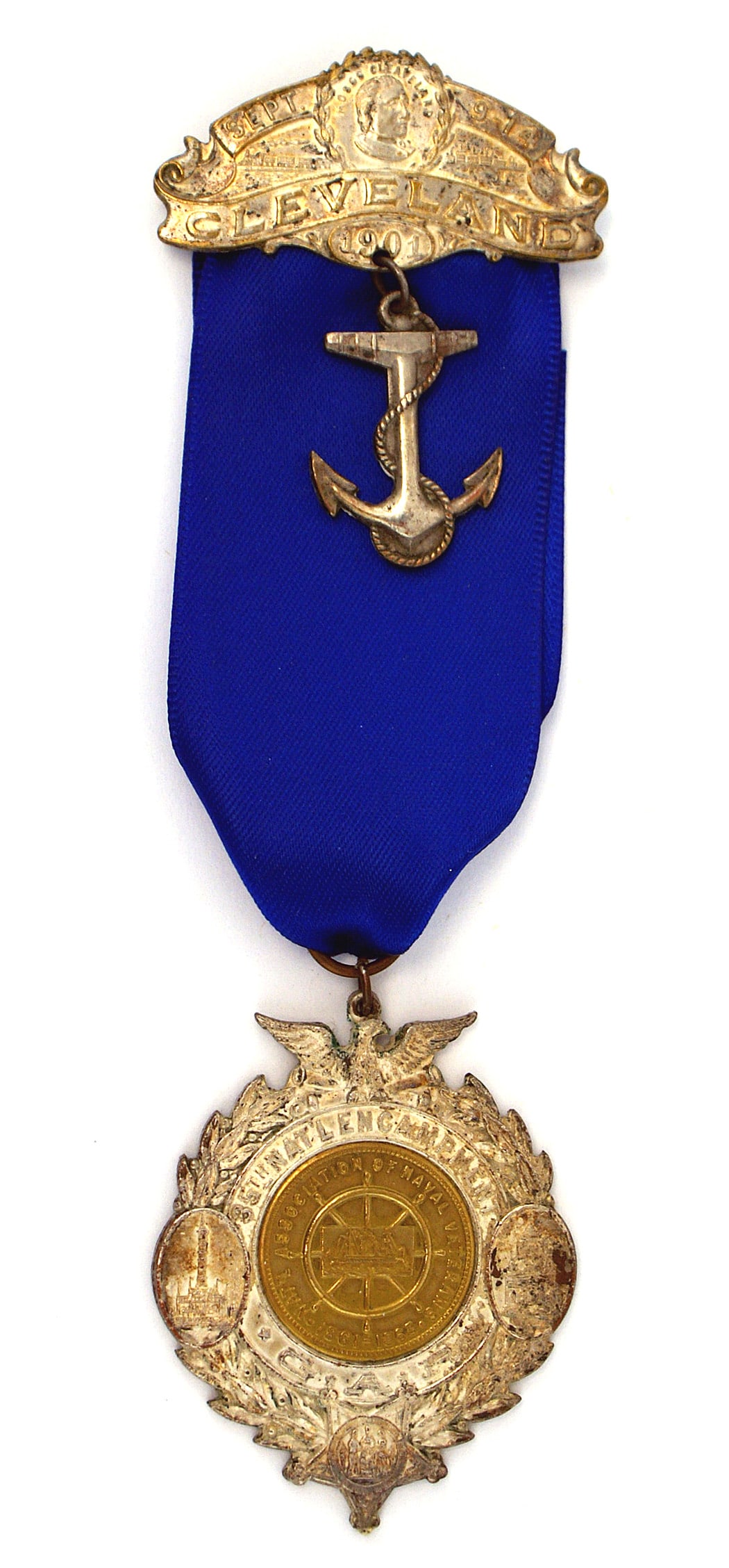 GAR Navy Veterans 35th National Encampment Badge: K-013 U.S. Civil War Gar Navy Veterans 35th National Encampment Badge. Large, silvered oak leaf wreath with an eagle. Scenes of buildings and "35th Nat'l ENCAMPMENT GAR". Gilt "coin" shape insert of a