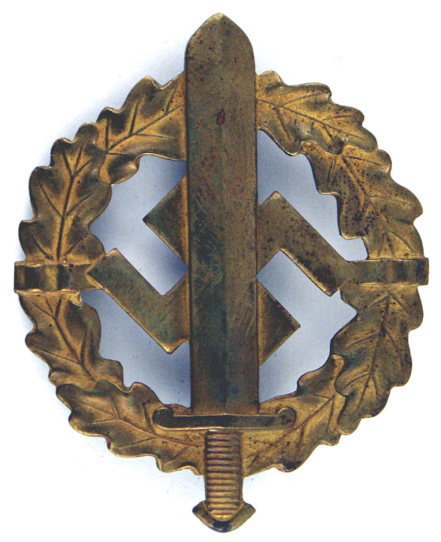 German WWII SA Sports Badge Gold: B-023 SA Sports Badge - Gold. Broadsword and swastika on the open center of an oak leaf wreath Gold finish has an aged patina. Reverse is marked "EIGENTUM D. CHEFS D. AUSBILDUNGSWESENS - LUDENSCHEID" 