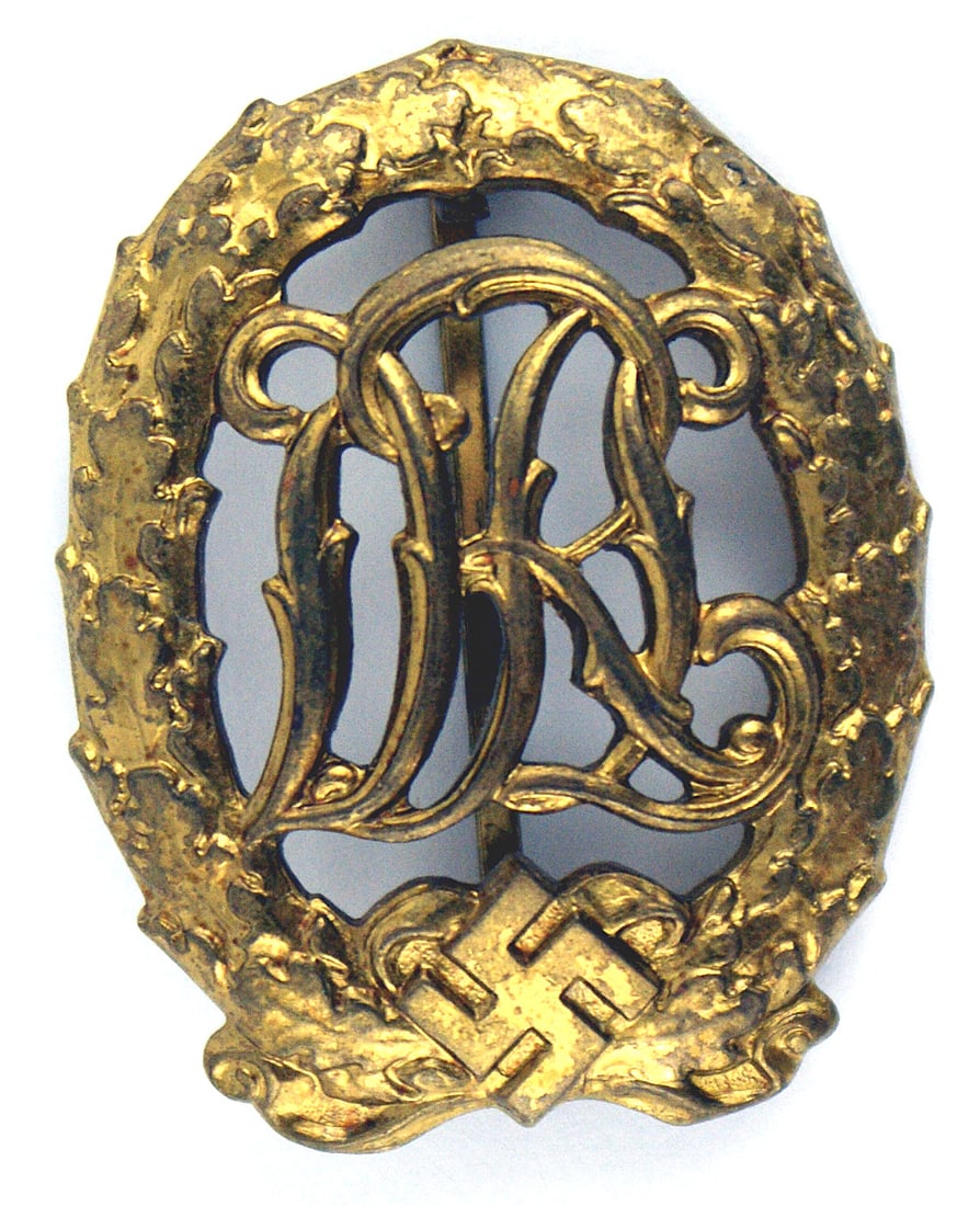 German WWII DRL Sports Badge Gold 1937: B-024 DRL Sports Badge Gold - (1937). Convex open leaf wreath/swastika holding a cypher "DRL". Wide vertical pin. Marked "WERNSTEIN JENA" and "D. R. G. M. 35269" Excellent. I