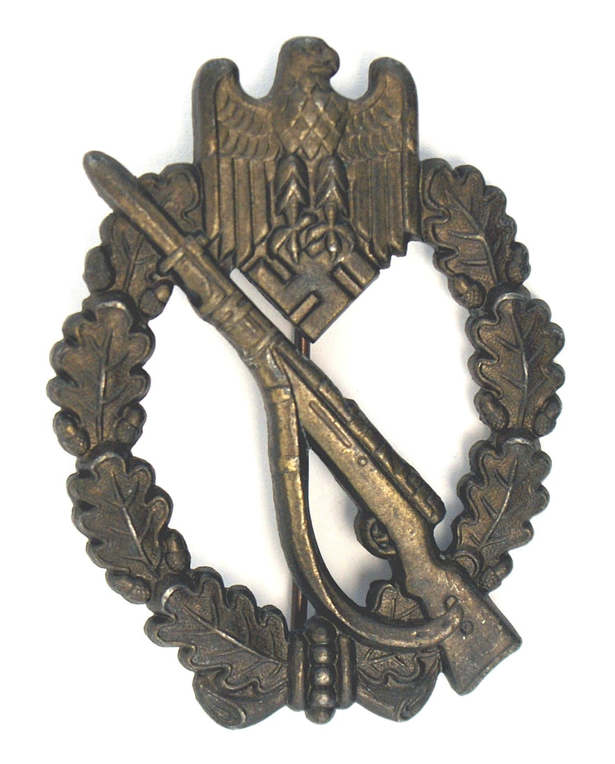 German WWII Infantry Assault Badge Silver: B-054 German WWII Infantry Assault Badge - Silver. Eagle/swastika at top of an open oak leaf wreath - holding a rifle with a fixed bayonet. Solid brass construction with 100% bronze finish. Reverse ma