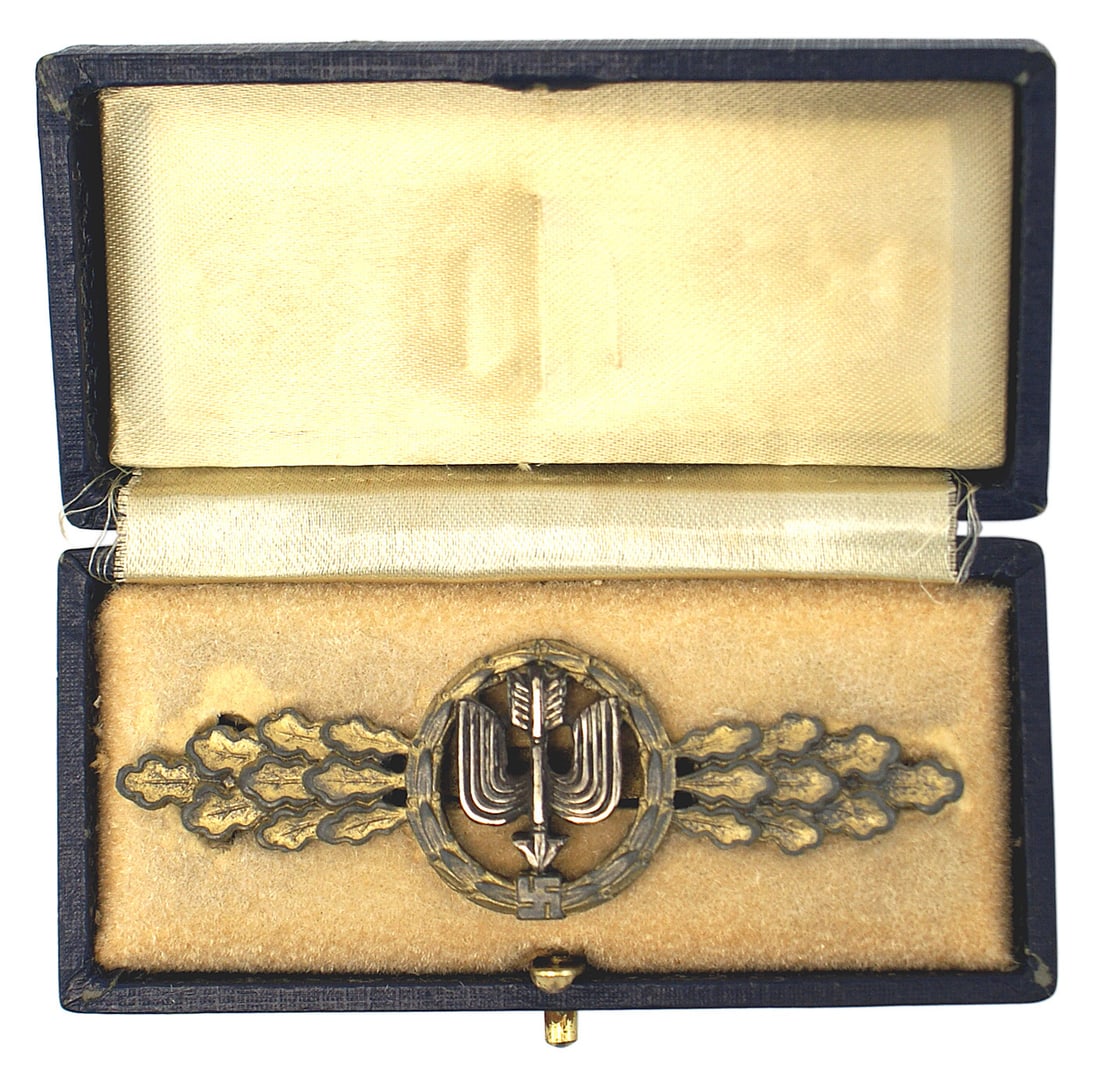 WWII Luftwaffe Long Range Pilot Clasp: B-067 German WWII Luftwaffe Gold Long Range Day Fighters and Air-to-Ground Support Squadrons Clasp 1941-44. Spray of an open wreath (with a swastika) holding a winged downward pointed arrow. Reverse m