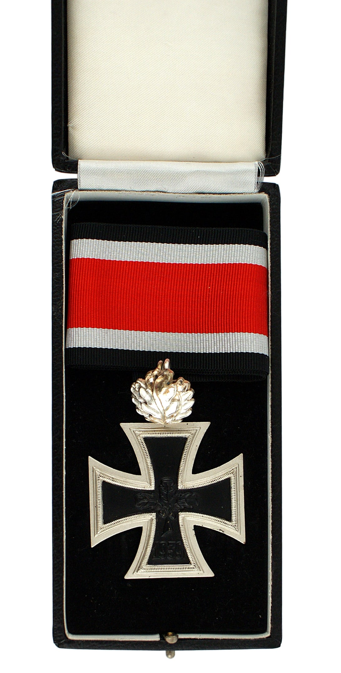 German 1957 lot Knights Cross Oak Leaves: B-084 German 1957 cased Knights Cross of the Iron Cross with Oak Leaves. The cross has three oak leaves and "1939" on the obverse of the black iron center. Reverse marked "1813". Dull silver frame mar