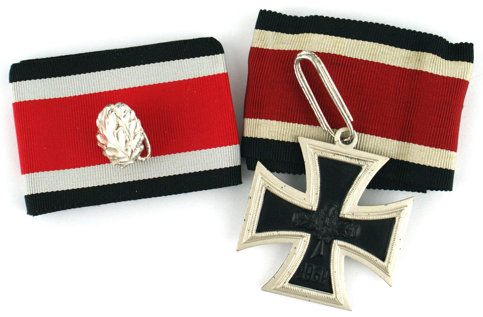 German 1957 lot of 2 WWII Knights Cross Oak Leaves: B-086 German 1957 lot of 2 WWII awards: (1) Knights Cross of the Iron Cross. There are three oak leaves and "1939" on the obverse of the black iron center. Reverse marked "1813". Dull silver frame mar