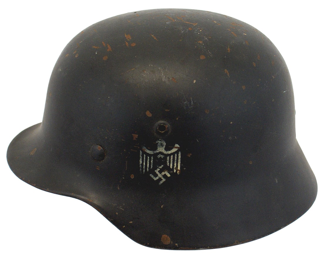 German WWII Army M1935 helmet: E-019 German WWII Army M1935 "Stahlhelm". Blue-gray finish with some small scratches and chips along the top. The left side is a white stenciled eagle/swastika. Tan leather drawstring liner shows wear