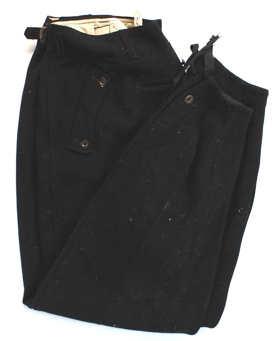 German WWII Waffen-SS black Panzer trousers: F-008 Waffen-SS black Panzer trousers. Two slant, and one watch pockets. Tapered legs with one button and cloth ties. One button down hip pocket. Two cloth side belts. Lining is stamped with sizing an
