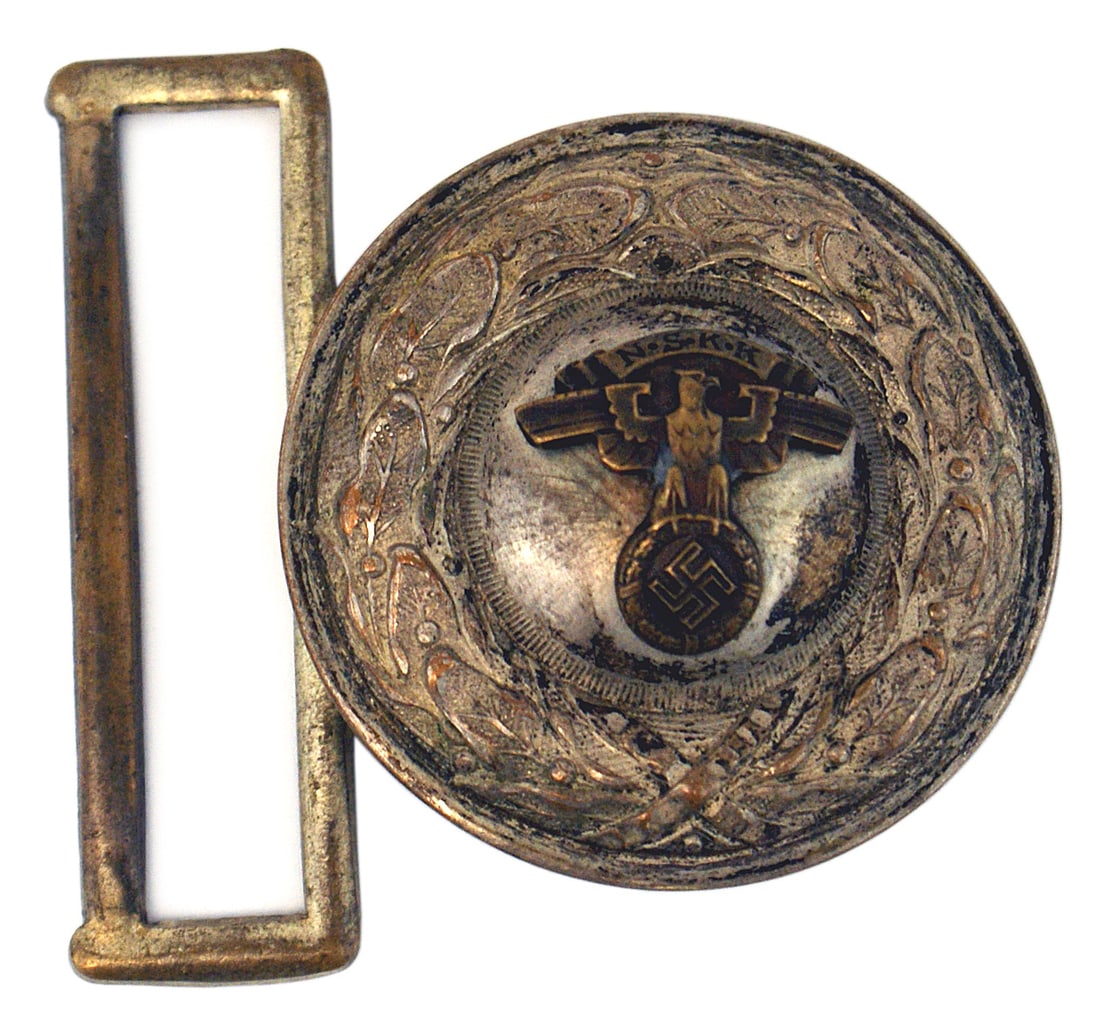 German WWII NSKK leader belt buckle: H-004 German Third-Reich N.S.K.K. leader's belt buckle. Silvered finish round oak leaf buckle with a relief bubble center to which a convex N.S.K.K. legend/swastika is affixed. Most of the silver fini