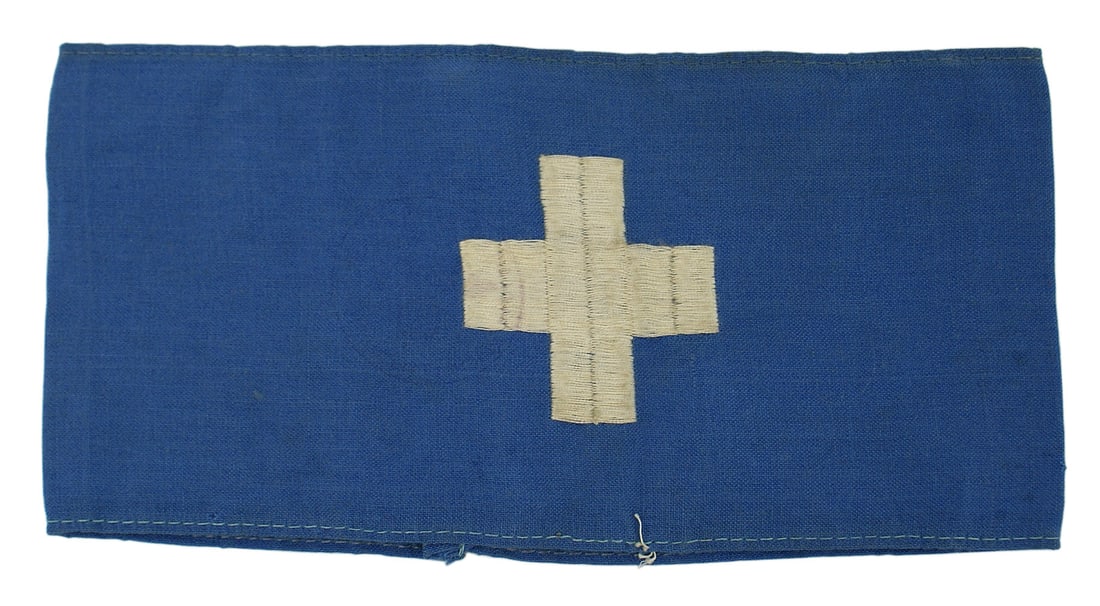 German WWII Werkluftschutz armsband: H-012 German Third-Reich/WWII Werkluftschutz armsband. Light blue cloth band with an embroidered bevo white cross. II