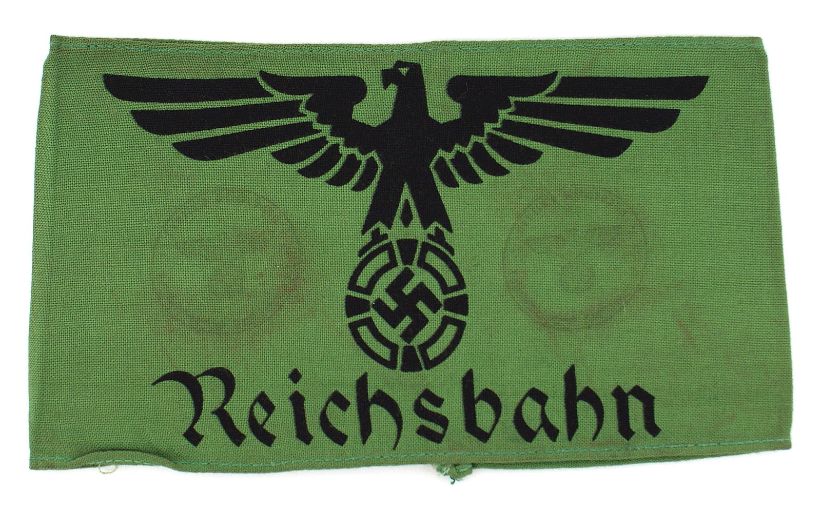 German WWII National Railways armband: H-013 German Third-Reich/WWII National Railways armband. Large black eagle/swastika and "Reichsbahn" printed on a green band. Ink stamps partially visible. II