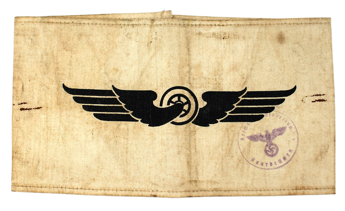 German WWII Reichsbahn armband: H-014 German Third-Reich/WWII Reichsbahn armband. Black printed winged-wheel on a white band. Ink stamp has an eagle/swastika and "Reich... direction - Saarbrucken". Soiled. Scarce. II-