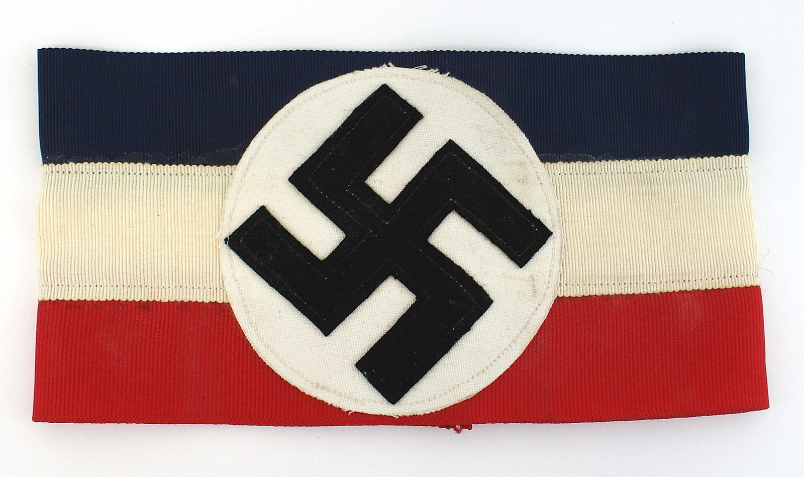 German WWII American Bund armband: H-016 German American Bund armband. 3 1/8 tilted black felt swastika sewn to a white roundel, sewn to a red/white/blue ribbed ribbon - like material. Well made. I