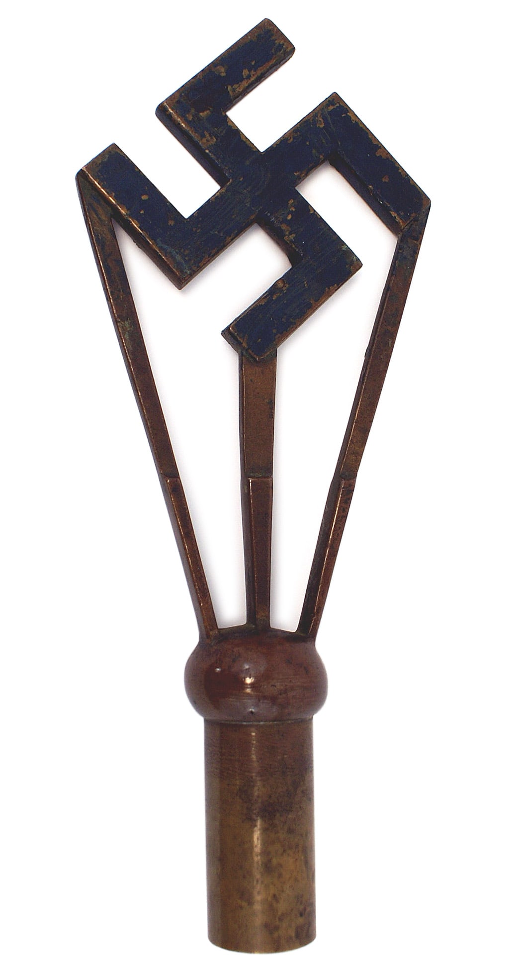 German American Bund flag pole top: H-073 German-American Bund flagpole top. Blackened 3" x 3" titled brass swastika resting on three rays emanating from the ball shaped top of a 3 1/2" brass pole sleeve. Overall 10 3/4" with an aged pa