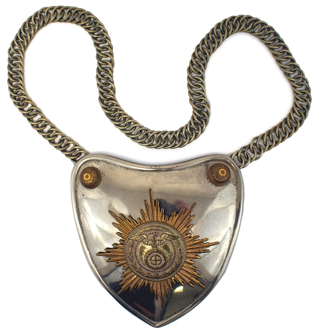German WWII SA SS gorget early type: H-086 SA/SS gorget. Early type "polished" heart shape, with an affixed brass 8-pointed starburst. Center has a defined silvered disc of a relief short winged eagle/"sun-wheel" swastika and oak leaves.