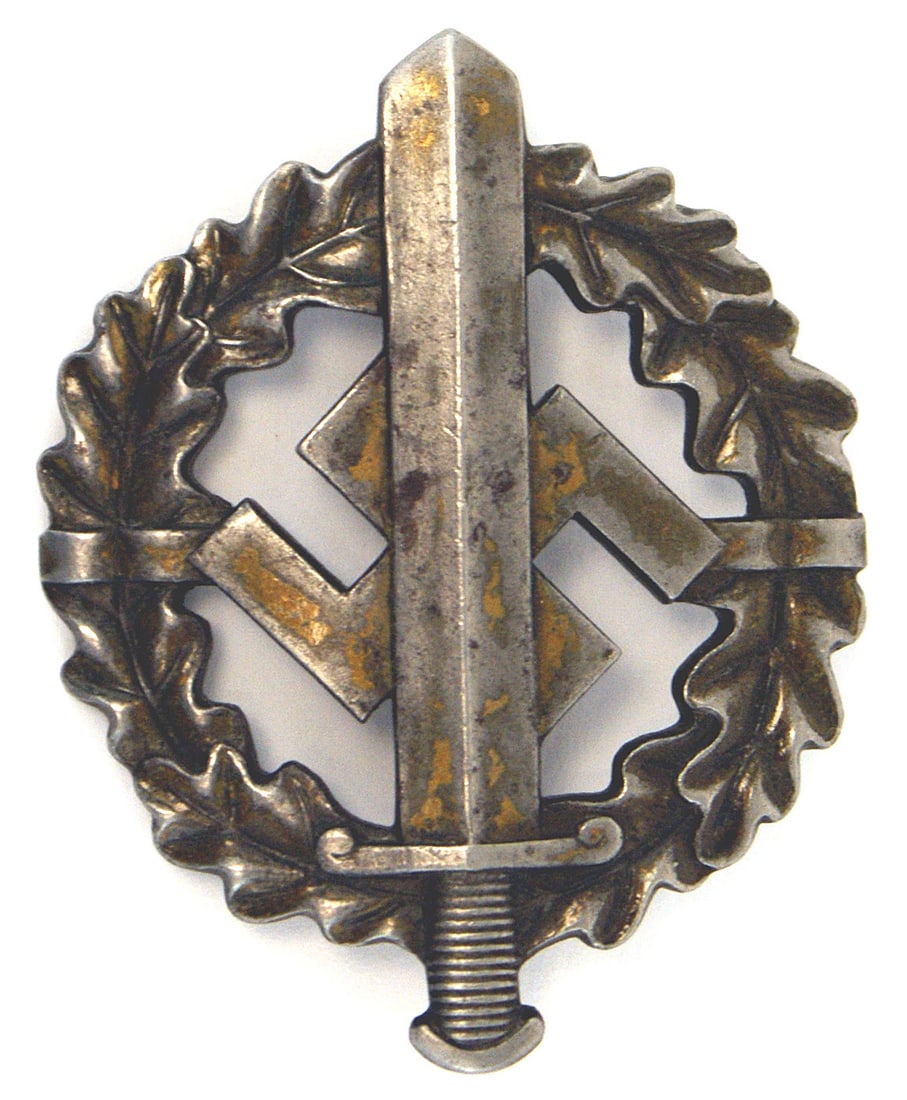 German WWII SA Sports Badge: B-032 SA Sports Badge. Large broad sword/swastika on an open oak leaf wreath. Some traces of bronze finish on sword. Reverse marked "EIGENTUM der Obersten SA FUHRUNG". Also "W. REDO - SAALAUTERN". 193