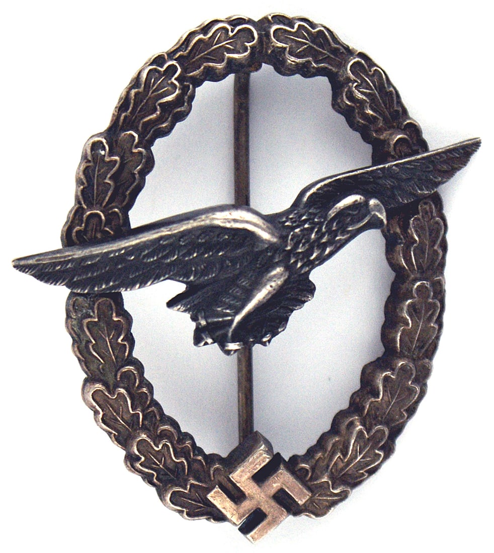German WWII Luftwaffe Gilder Pilot Badge: B-070 German WWII Luftwaffe Gilder Pilot Badge. Black "sailing" eagle on an age darkened oak leaves silver wreath with a swastika at the base. Two domed rivets on the reverse. Back of eagle is maker m