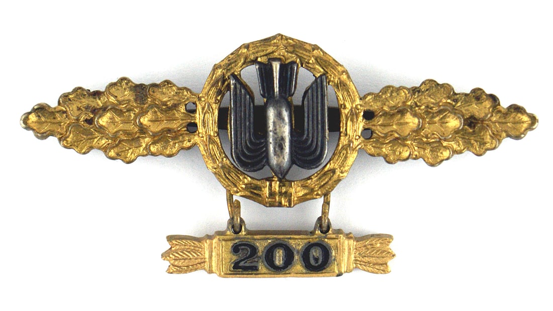 Luftwaffe Bomber Operational Flying Clasp: B-074 German WWII Luftwaffe Bomber Operational Flying Clasp in Gold with pendant. A cut-out oak leaf wreath holds a winged bomb which sits the middle of spray of oak leaves. Pendant with "200" is for