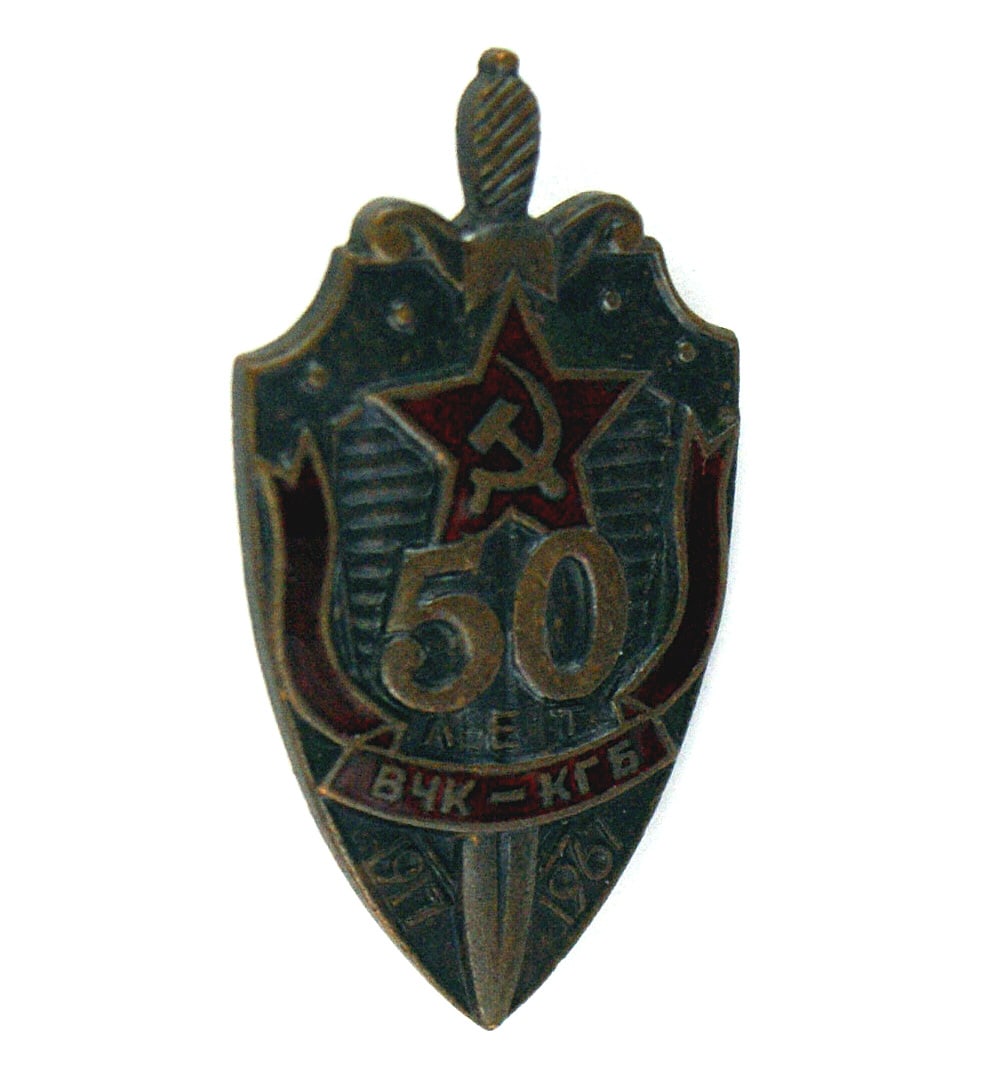 Russian medal badge 50th Anniversary of the KGB: B-140 Soviet Russian award badge in commemoration of the 50th Anniversary of the KGB. Darkened Shield shaped badge with a vertical sword, "50" in relief, a red enamel star with a hammer and sickle, a