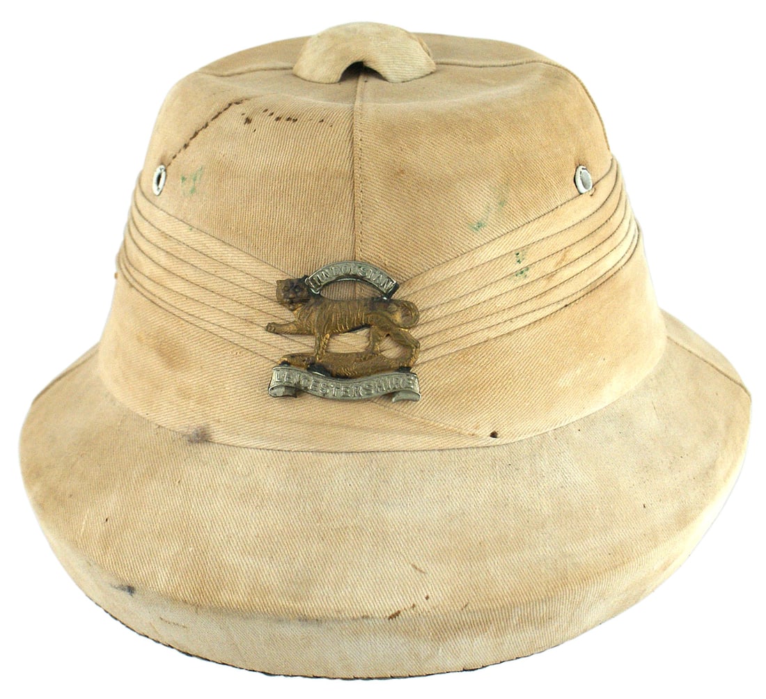 British WWII white pith helmet: E-026 British WWII white pith helmet with a 1" brim. Regimental cap badge of the "HINDOOSTAN LEICESTERSHIRE" has been attached for some time. Tan leather liner and cross straps. Plastic moisture shiel